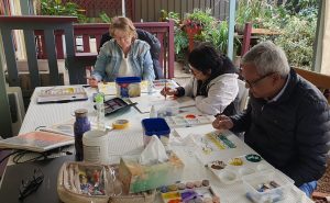 A photo of students focusing on artworks in the Cviisual Art Studio outdoor workspace.