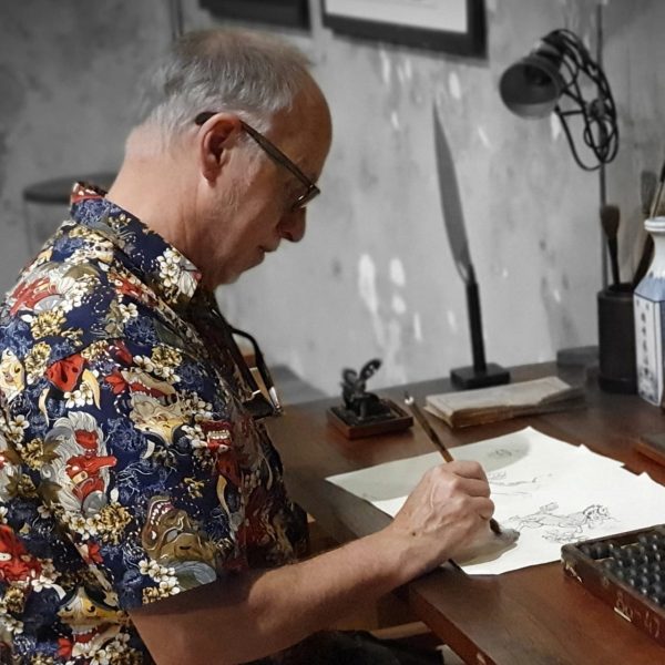 A photo of artist Stuart Ian Currie busy drawing.