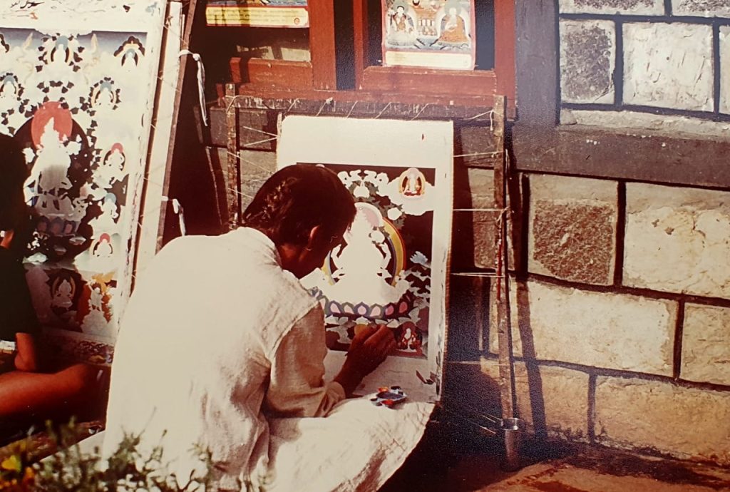 A photo of Stuart Ian Currie painting a Tibetan Thangka (religious painting).