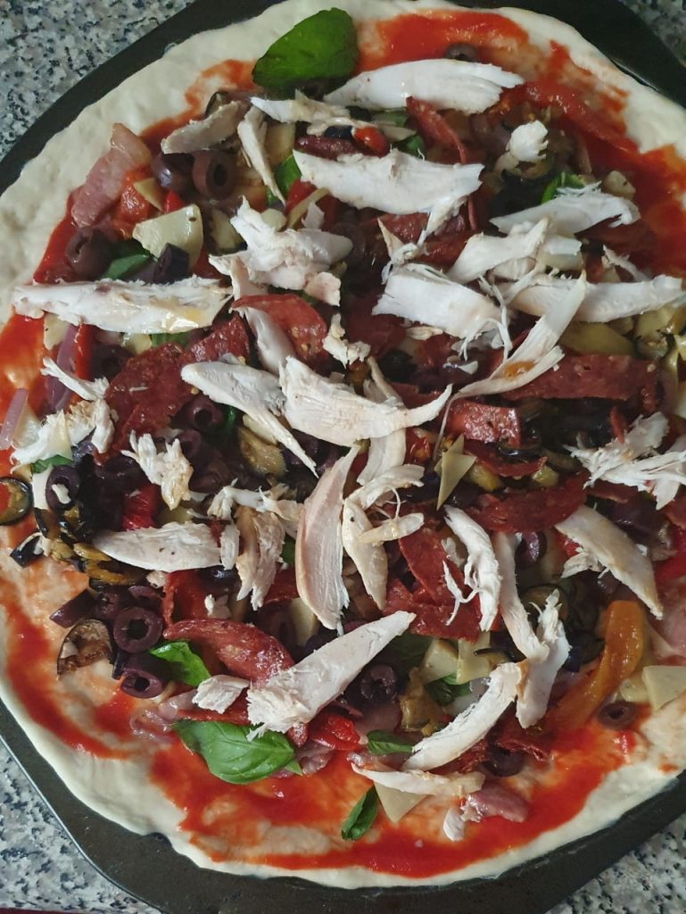 A photo of a home-made gourmet pizza ready for cooking.