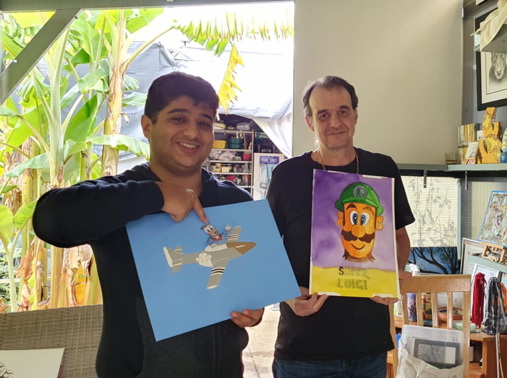 Art class students Jason and Thomas holding up their creations.