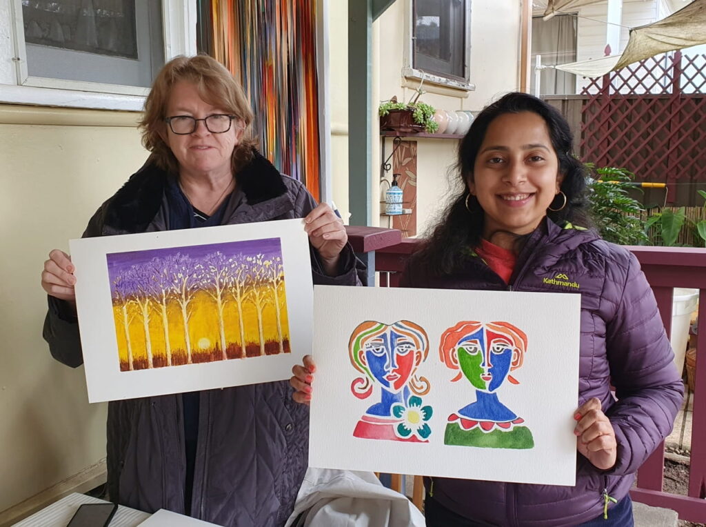 Art class students Janine and Rashmi holding their creations.