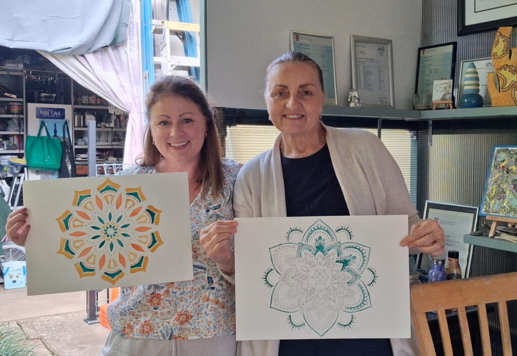 Art class students Rosalyn and Jo holding up their creations.