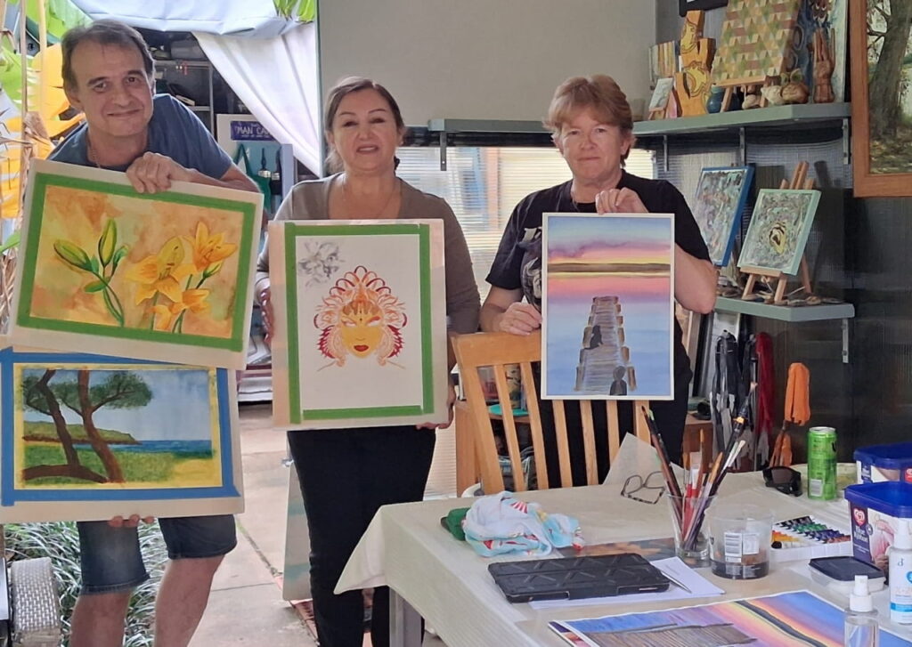 Art class students Thomas, Jessica and Janine holding up their creations.
