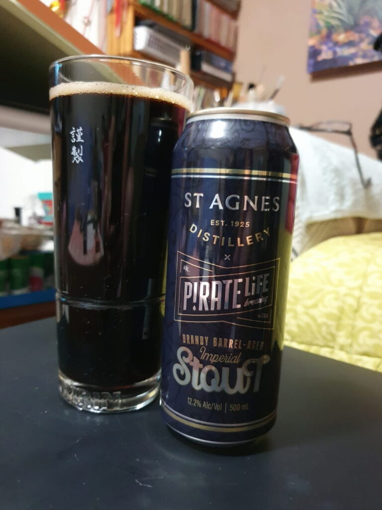 A tall glass of brandy-aged imperial stout beer next to the empty 500 ml can - a collaboration between Pirate Life Brewery & St. Agnes Distillery.